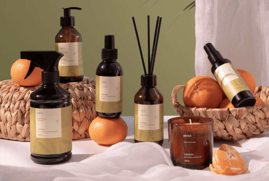 aromas para casa ARTEX dispostos em uma mesa com uma cesta e algumas laranjas