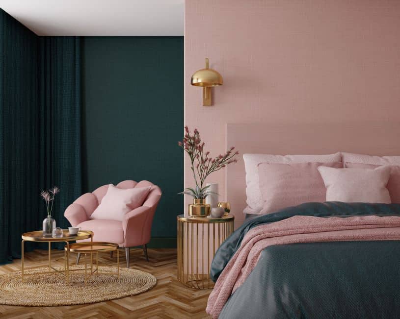 quarto rosa, dourado e verde, o espaço possui uma cama, duas mesas de centro, uma poltrona e uma mesa lateral