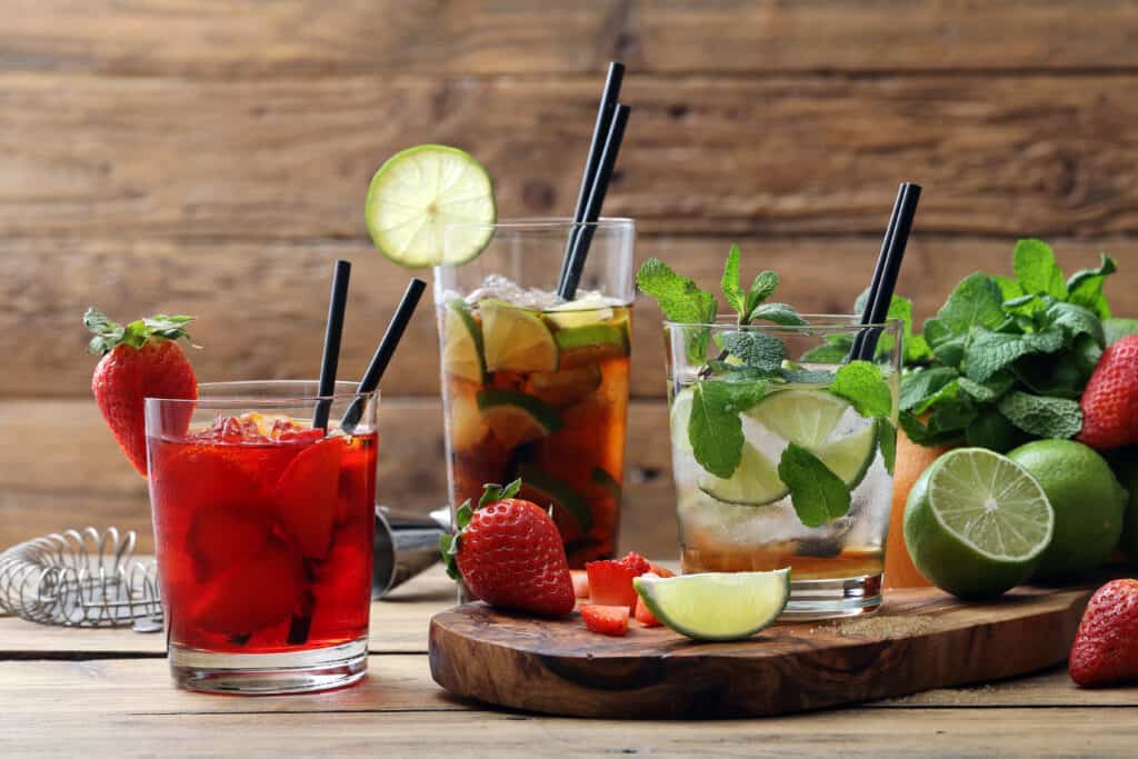 três drinks de frutas sobre uma mesa de madeira